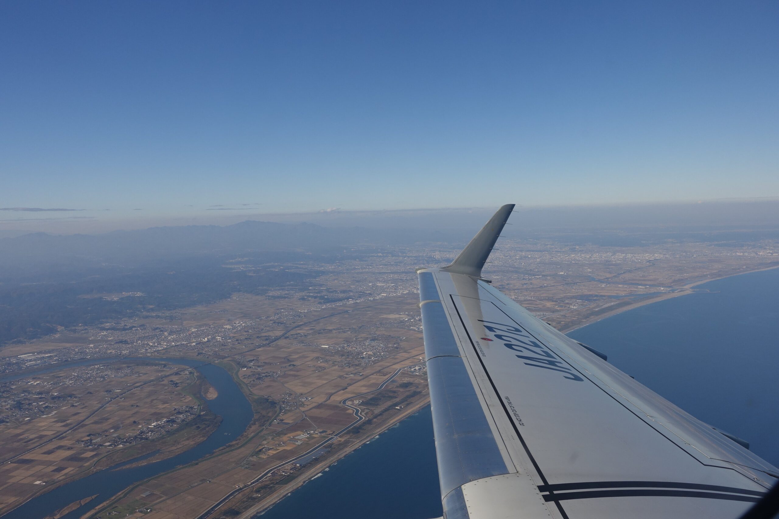 航空機から見た穏やかな海岸線と街並み